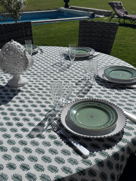 jolie table dressée avec une nappe block-print verte dans un jardin avec vue sur la piscine