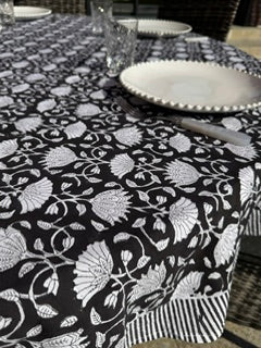 gros plan sur l'imprimé noir et blanc de la nappe présentée sur cette photo avec de la vaisselle blanche pour un style sobre et élégant, moderne et intemporel.