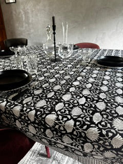 Gros plan sur une table décorée avec une nappe LOTUS bicolore noire/blanc pour un résultat moderne et sophistiqué