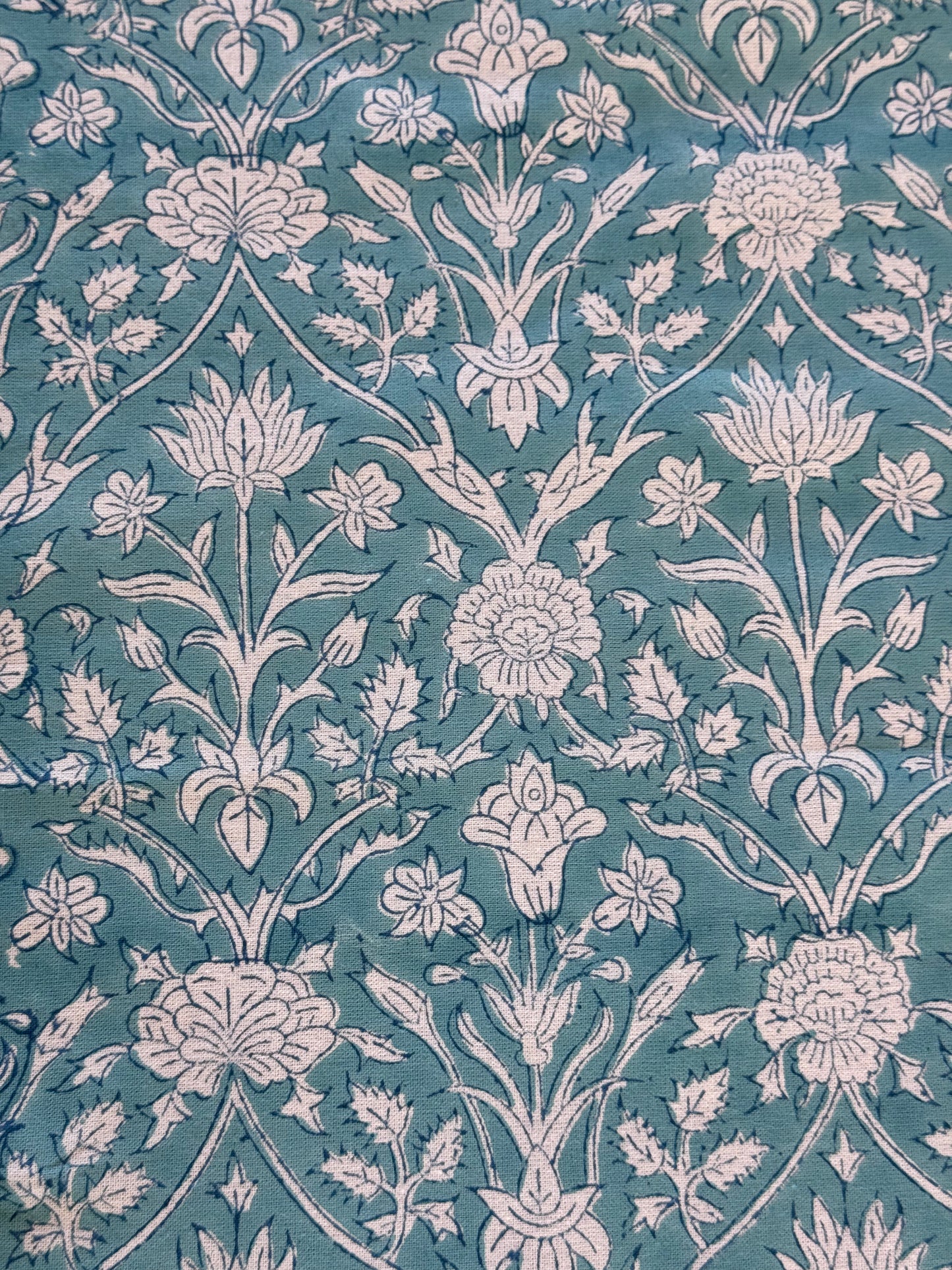Zoom sur les motifs fleuris de la nappe PADMA bleu,  imprimée artisanalement en Inde.